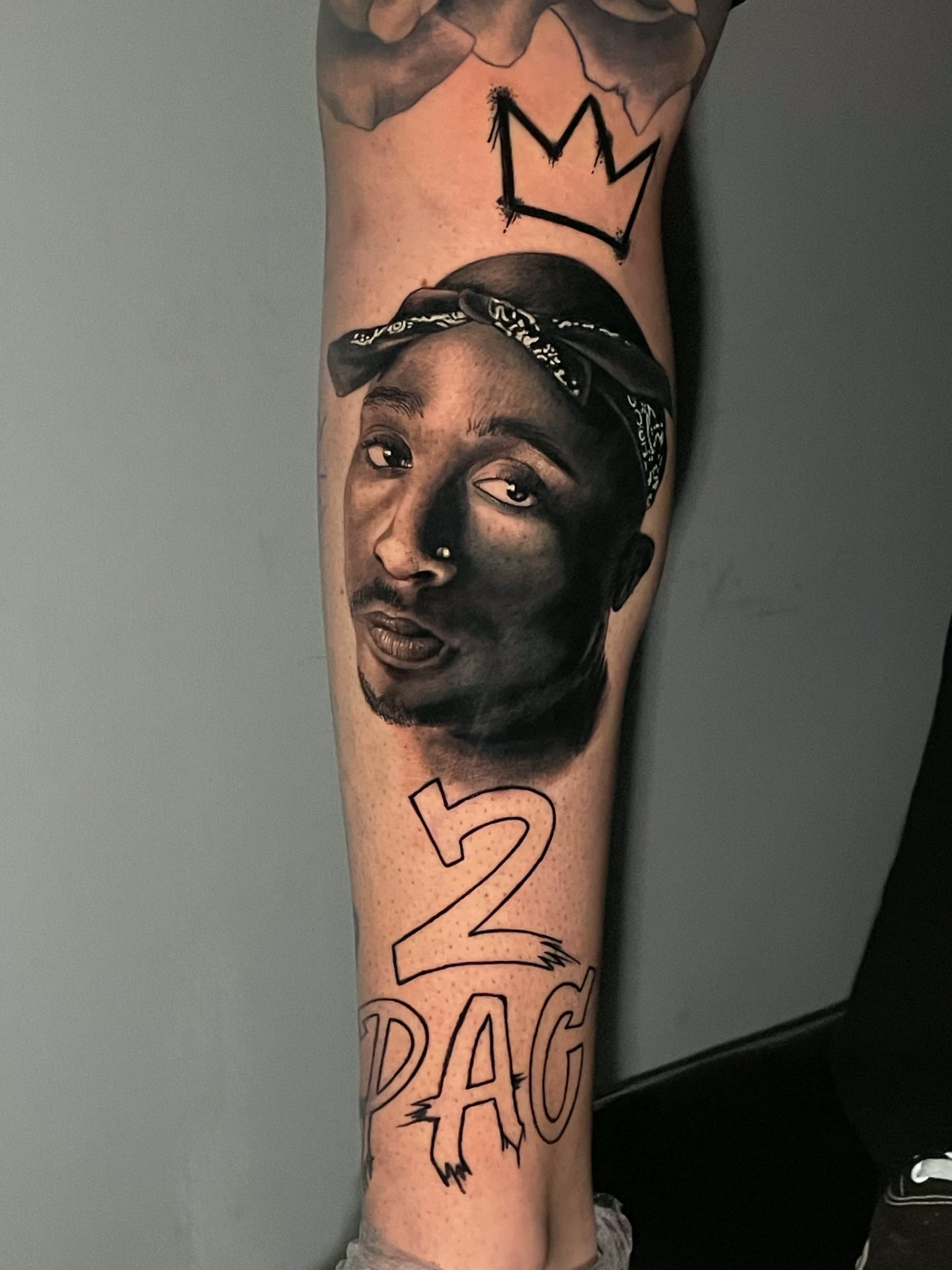 Tatuagem realista em preto e cinza do Tupac