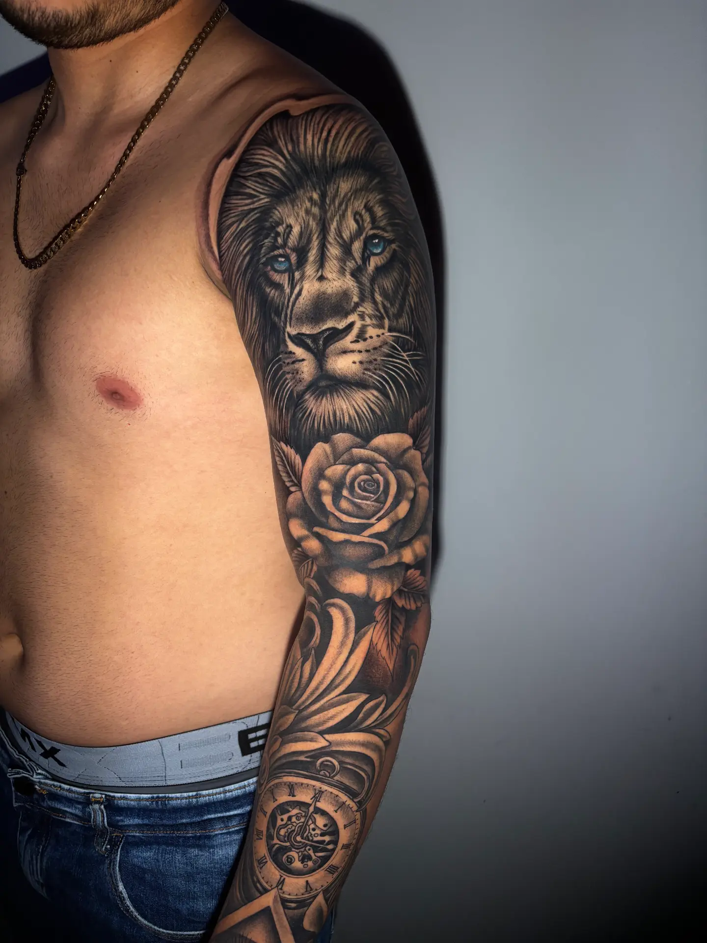 Tatuagem realista de leão com rosa e relógio