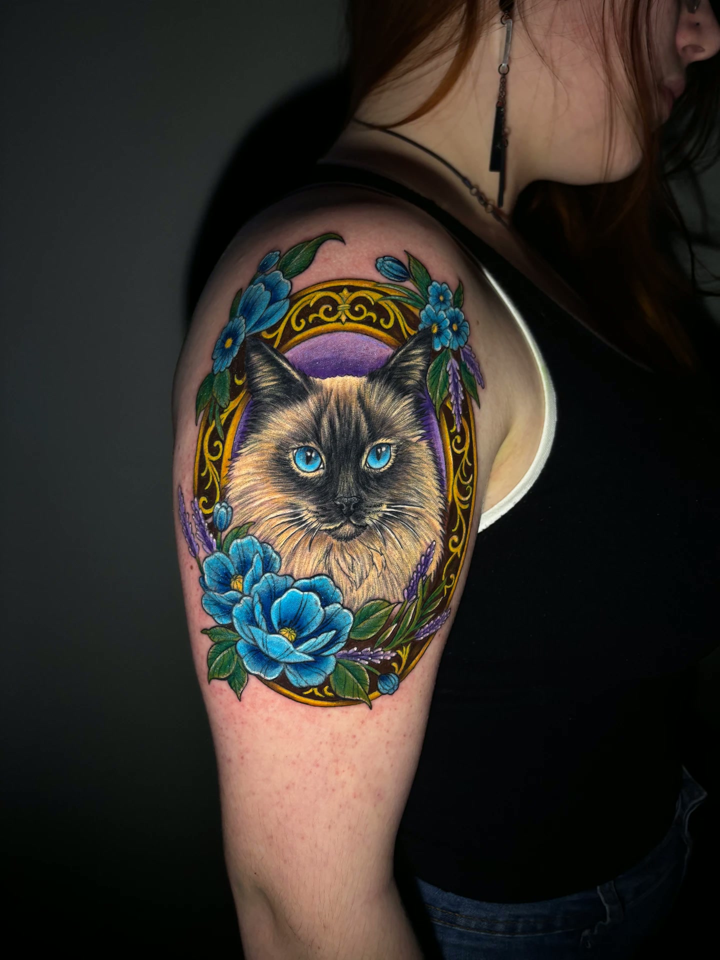 Tatuagem colorida de gato com moldura floral
