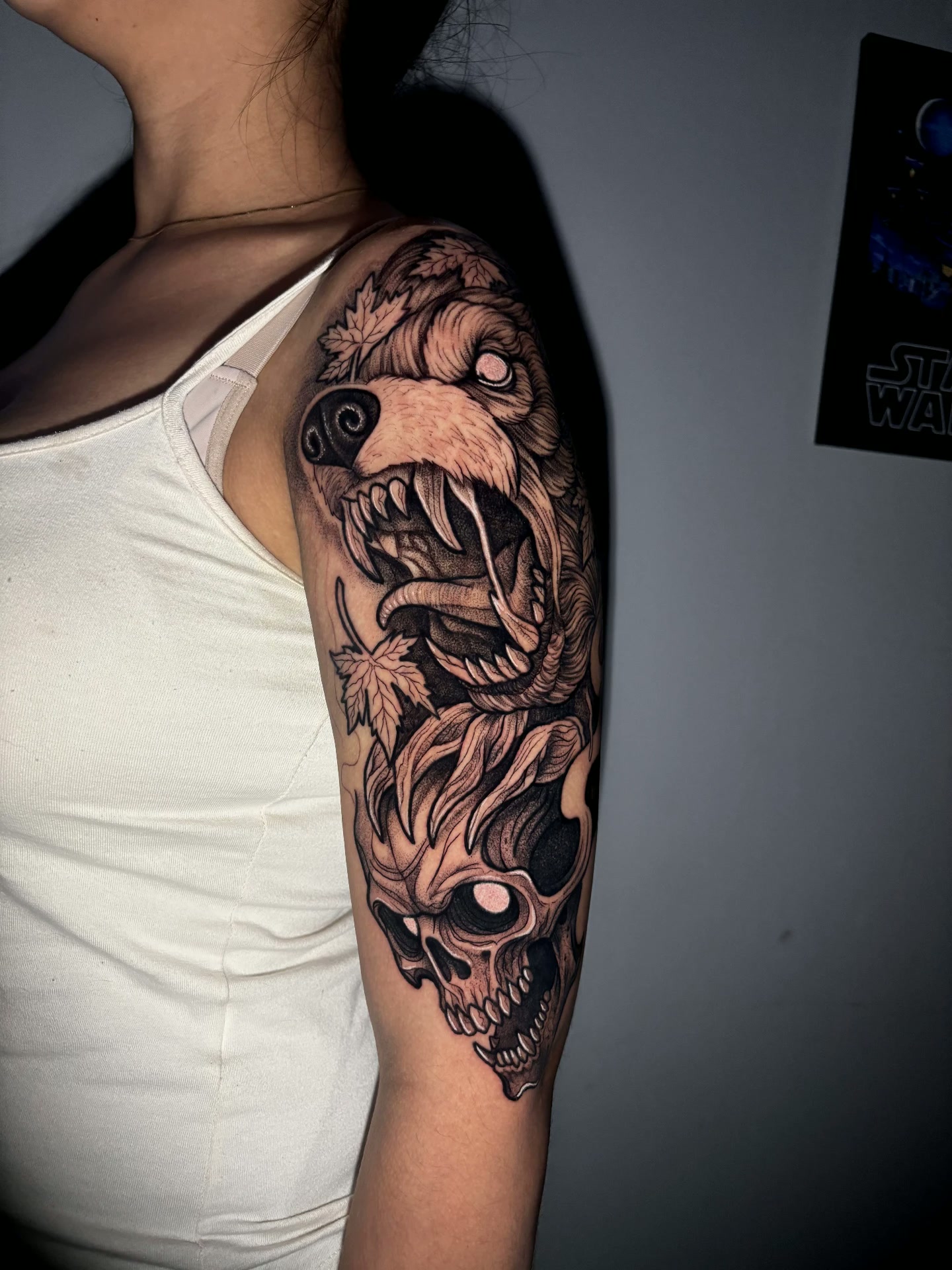 Tatuagem blackwork de caveira com folhas
